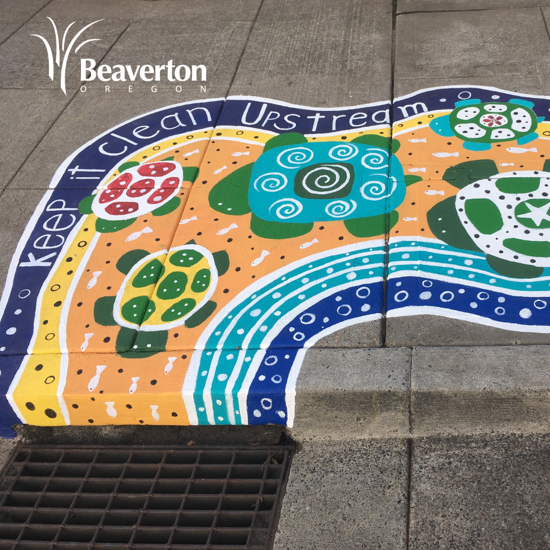 Photograph of a sidewalk painted in bright colors leading to a storm drain. The painting features turtles and the works 